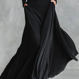 Nowoczesna długa sukienka z czarnego krepu z dekoltem w łódkę i plisami