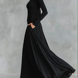 Nowoczesna długa sukienka z czarnego krepu z dekoltem w łódkę i plisami