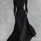 Nowoczesna długa sukienka z czarnego krepu z dekoltem w łódkę i plisami